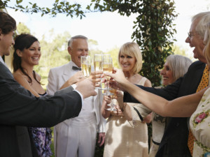 Bride and groom toasting with champagne and guests