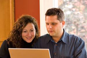 A couple both on a laptop searching for ideas to be successful. 