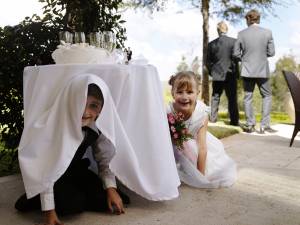 Children hiding underneath table at a wedding